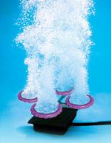 Photo depiction of an aerator sitting on a lake bed, plumes of air bubbles ascend, churning the water and adding oxygen.